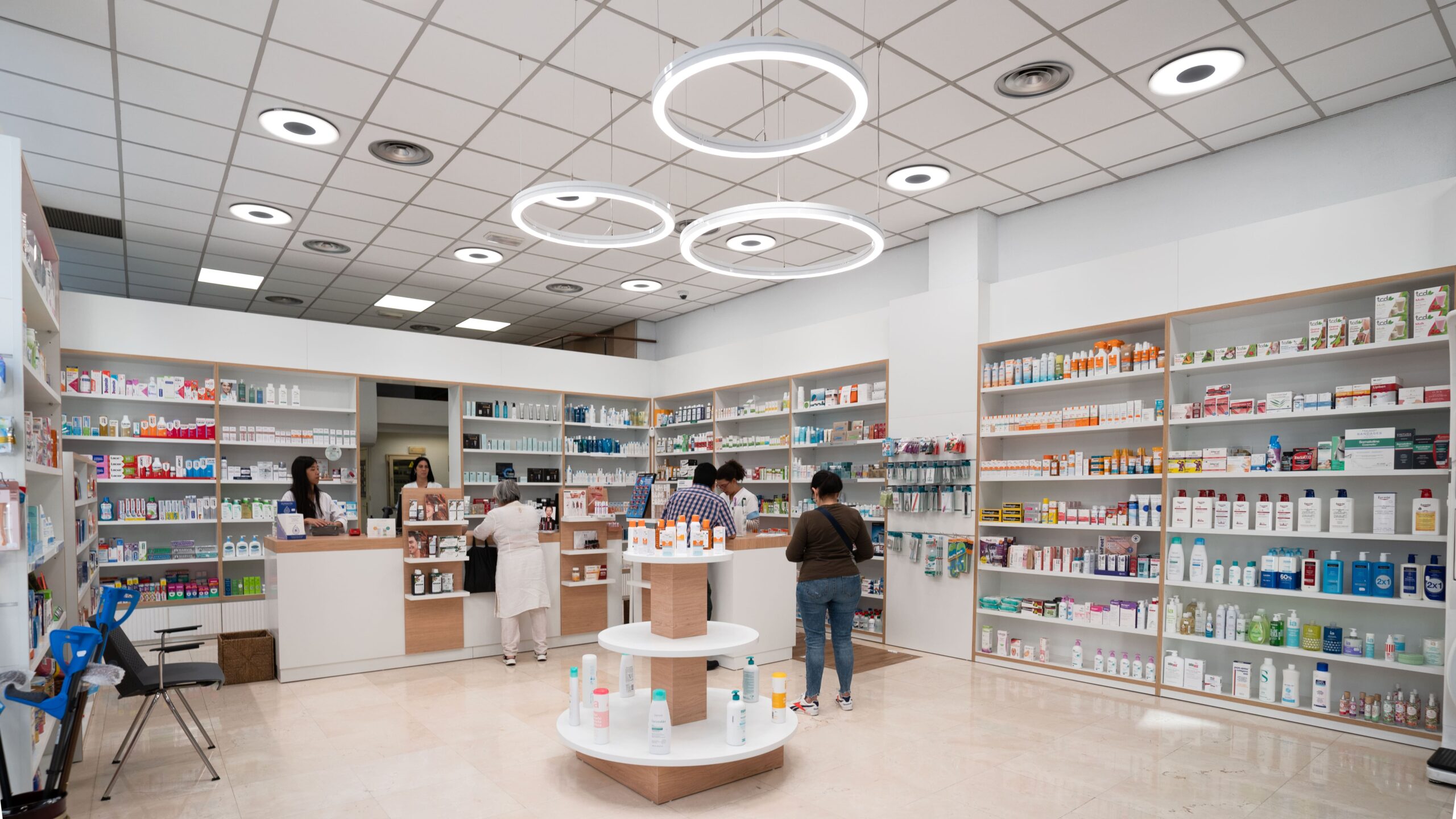 Farmacia con lámparas circulares suspendidas e iluminación LED en los lineales